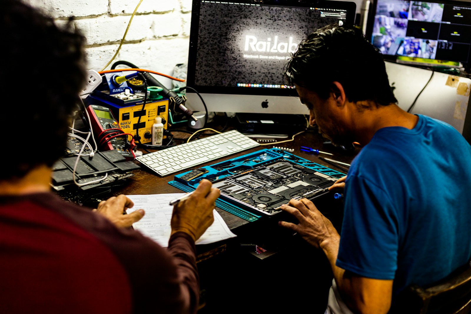 Technicians repairing laptop hardware